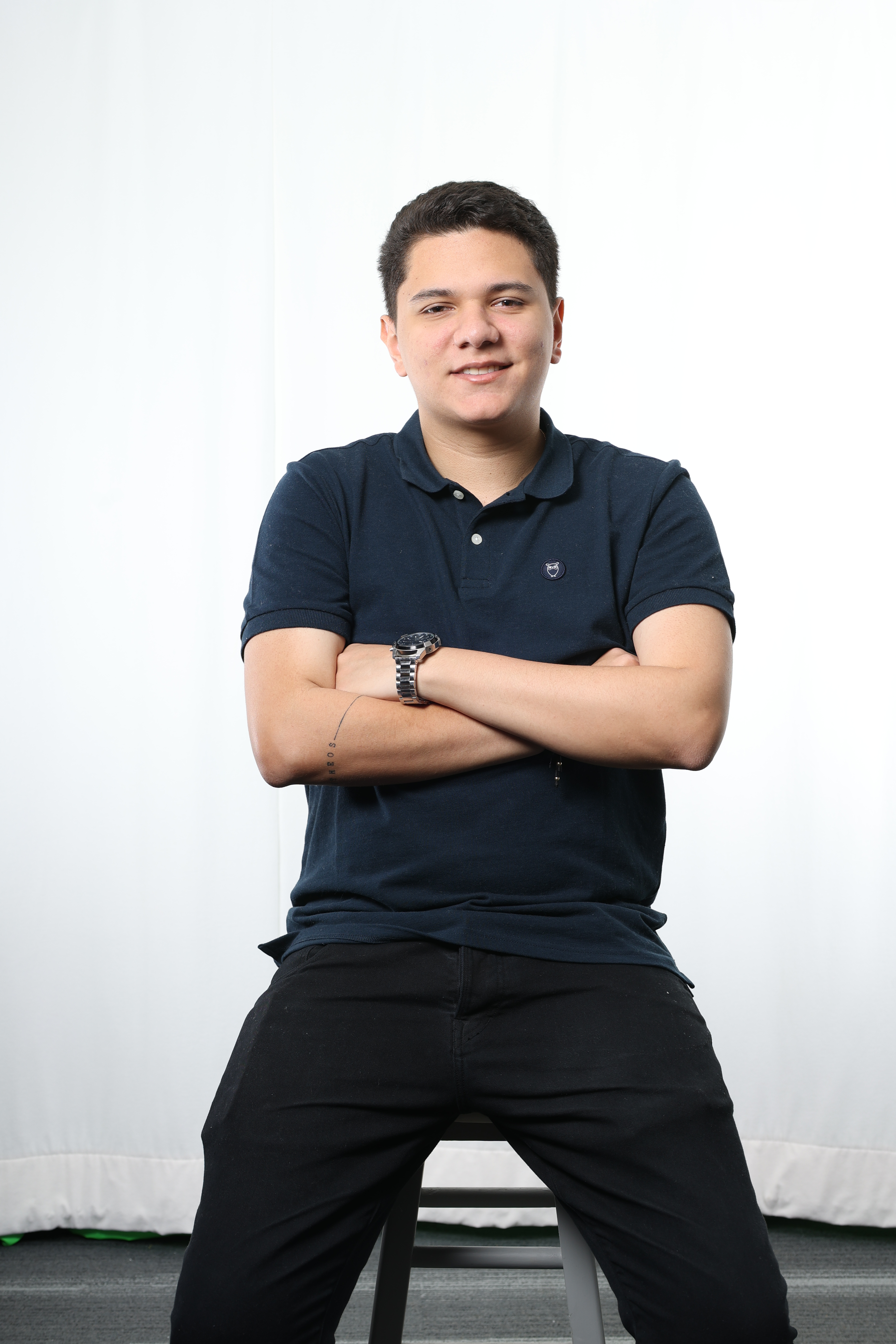 man with blue shirt sitting down