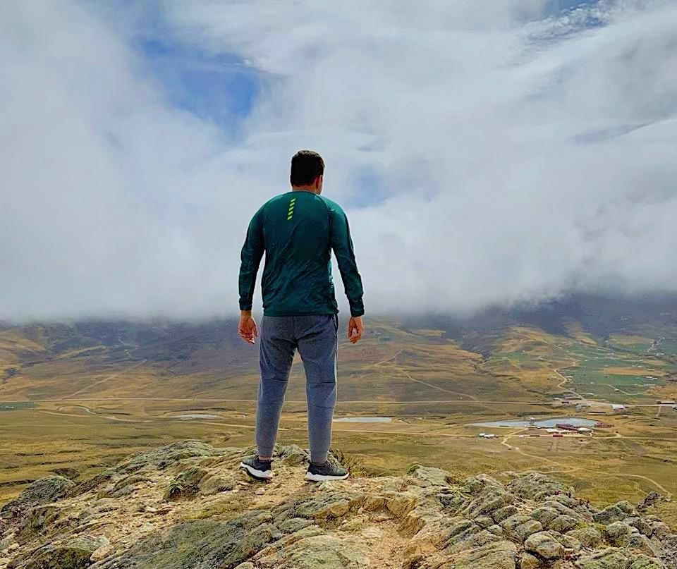 Person in a green shirt standing in a mountain